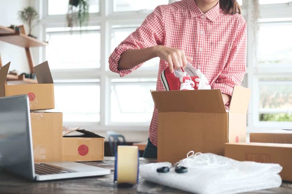 Person in a shop packing extra inventory, such as shoes, to bring to an UltraStor unit.