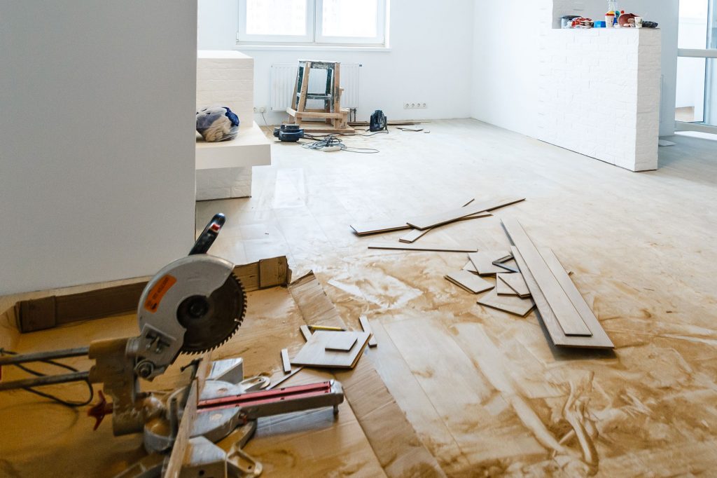 A home renovation underway, with various boards, a ladder and a table saw.