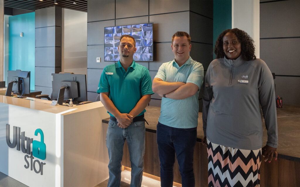 Photo showing three team members in front of the reception desk